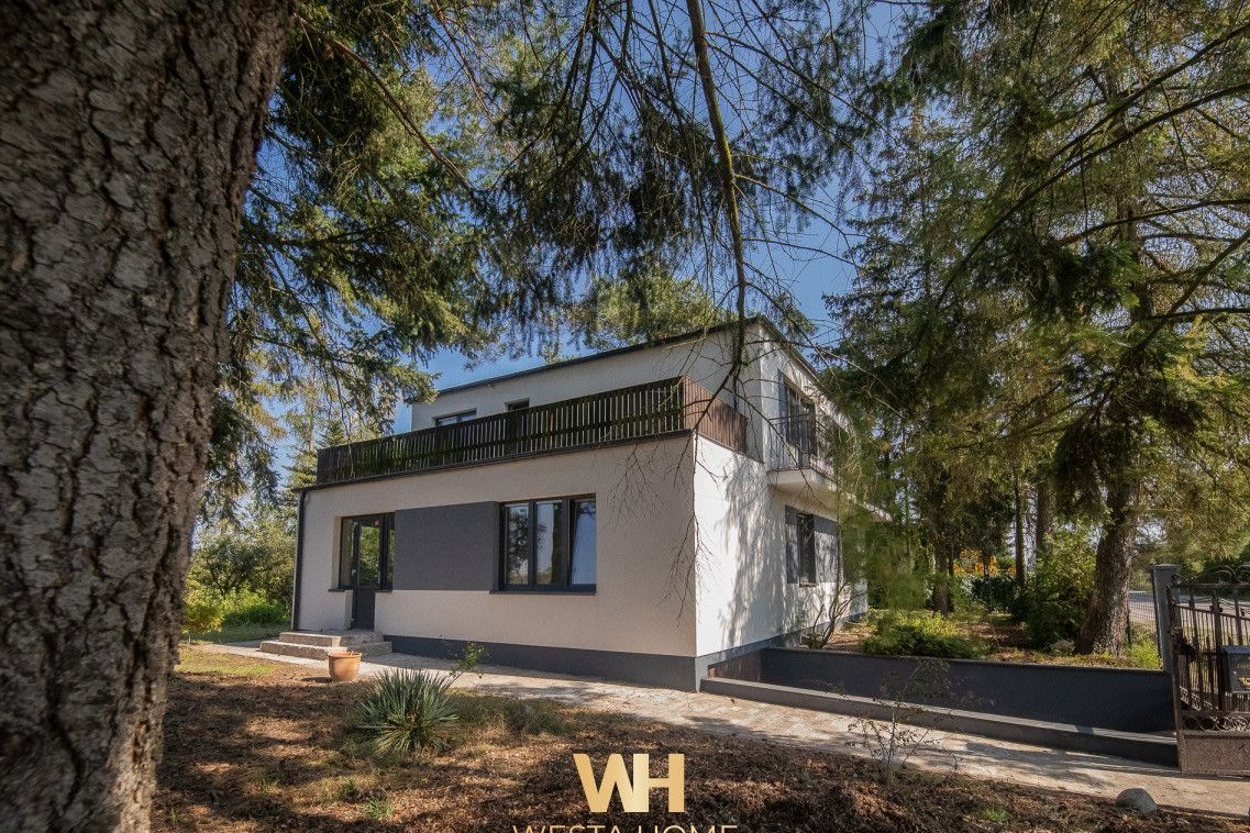 Dom wolnostojący w otoczeniu drzew. Zakroczym.