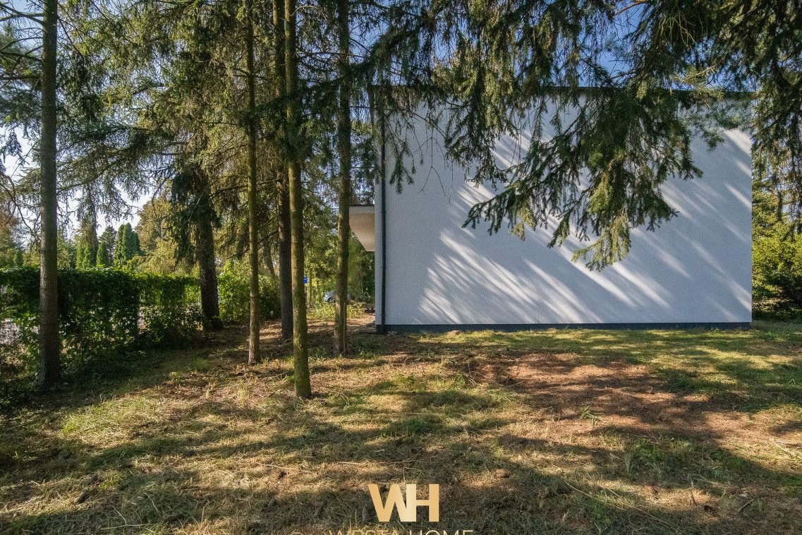 Dom wolnostojący w otoczeniu drzew. Zakroczym.