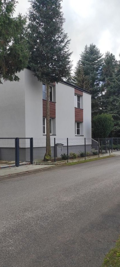 Zadbane siedlisko z dwoma oddzielnymi budynkami mieszkalnymi i lasem.